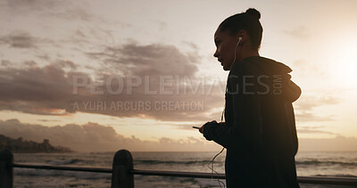 Buy stock photo Woman, earphones or beach sunset with music for listening or sports podcast in nature. Active, female person or runner with mobile smartphone for run, audio streaming app or workout playlist by ocean