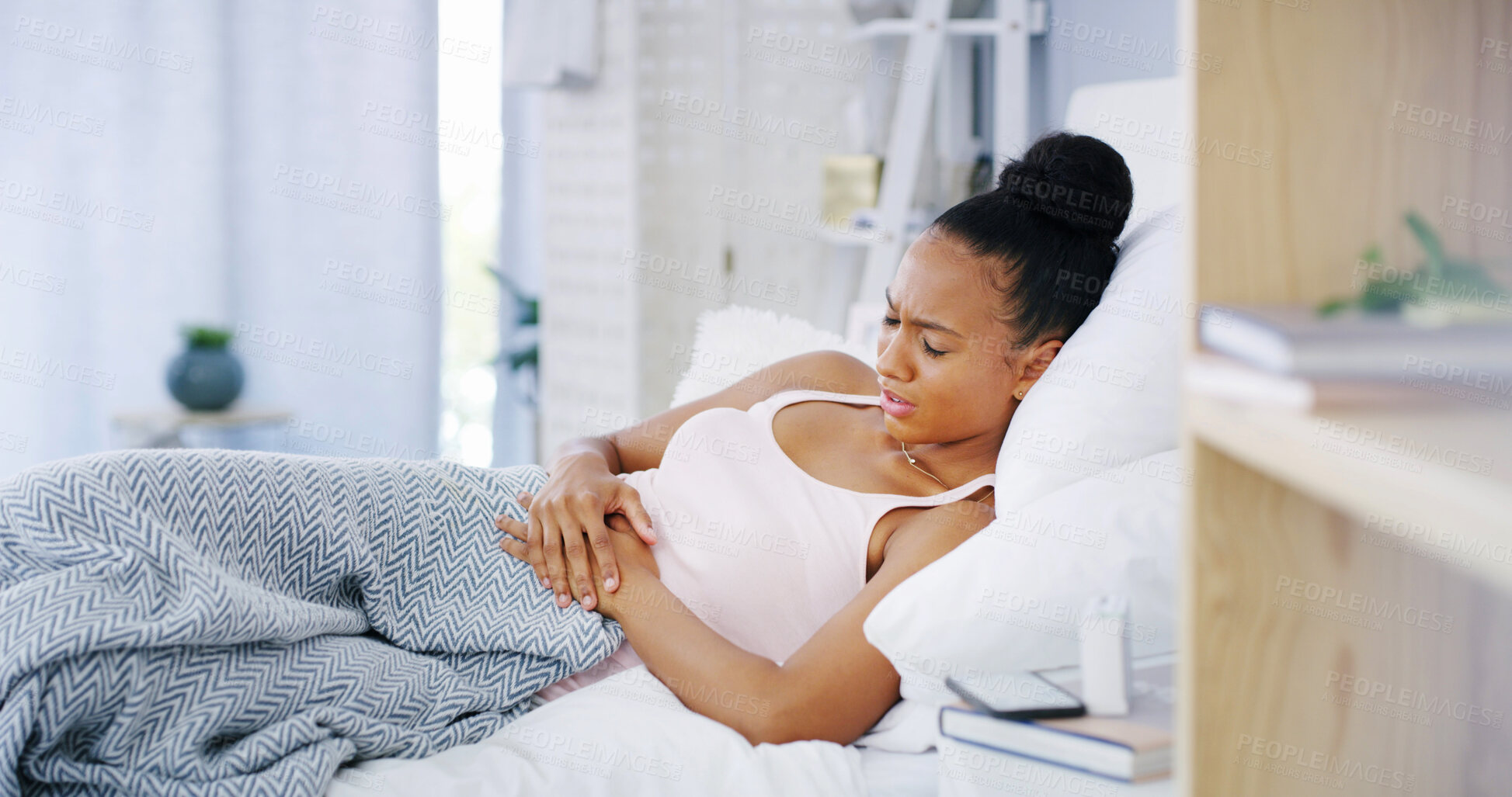 Buy stock photo Period, woman and stomach pain on bed in home with endometriosis, menstruation cramps or constipation. Sick, stress or girl with abdominal ache in bedroom for indigestion, nausea or medical emergency