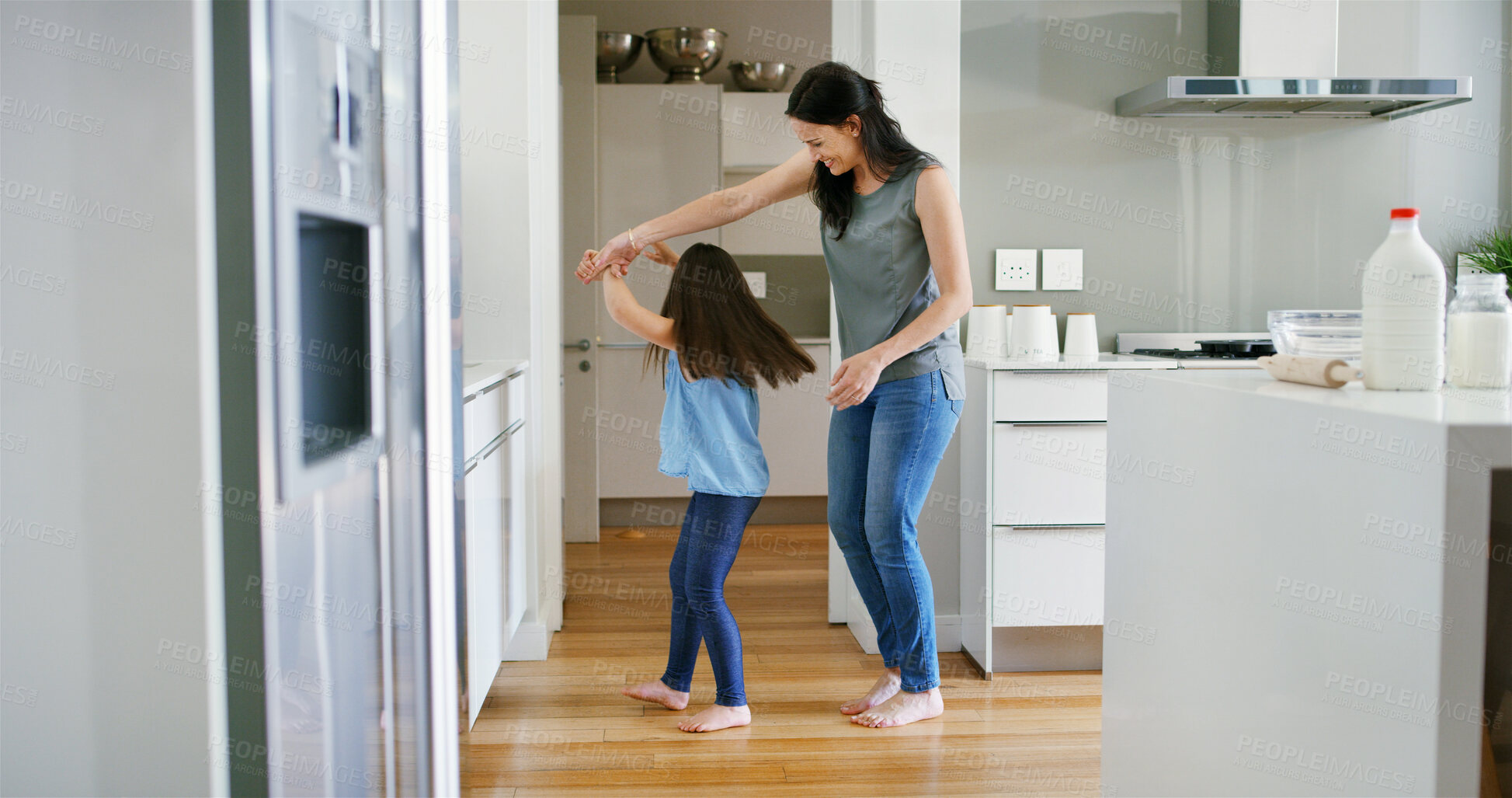 Buy stock photo Mom, daughter and holding hands for dancing in home, love and support with learning movement. Mother, girl and teaching steps to child in kitchen, family fun and listening together to sound of music