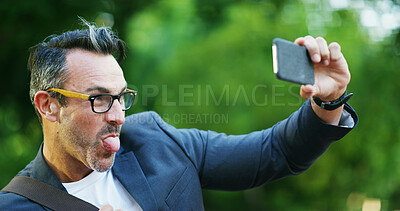 Buy stock photo Mature man, goofy face and selfie with tongue out in nature for silly picture, photography or outdoor memory. Funny, male person or comedian with expression for humor, capture moment or post at park