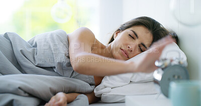 Buy stock photo Sleeping woman, hands and snooze alarm clock in bed for noise alert, wake up and stop timer in home. Morning, tired girl and press watch in bedroom to start day, resting and sunrise by bedside table