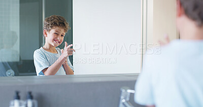 Buy stock photo Boy, child and mirror in bathroom with gesture for shooting, smile and funny face in family home. Kid, smile and wink with finger gun, reflection and playful with morning routine for hygiene in house