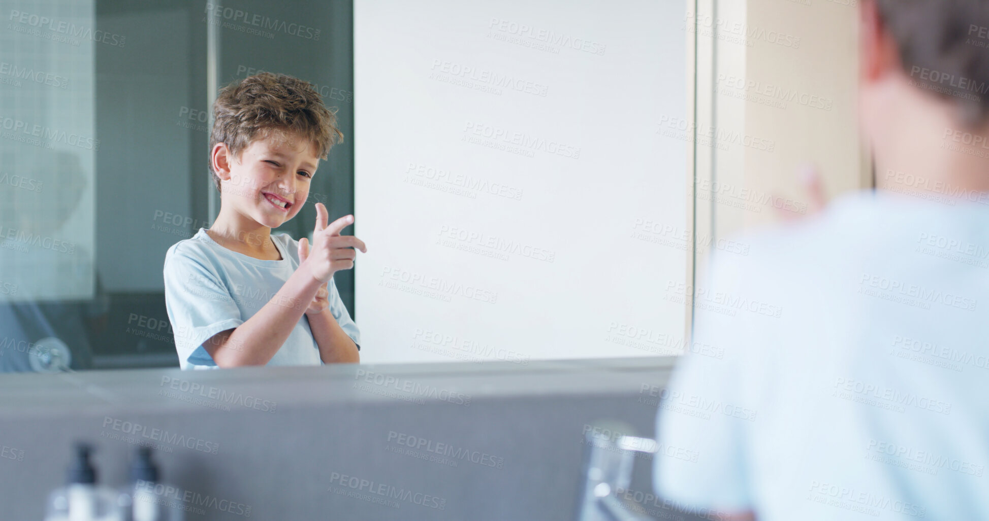 Buy stock photo Boy, child and mirror in bathroom with gesture for shooting, smile and funny face in family home. Kid, smile and wink with finger gun, reflection and playful with morning routine for hygiene in house