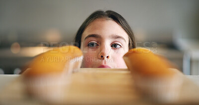 Buy stock photo Cupcake, baking and face of child in kitchen with snacks, hunger and morning meal on counter. Home, cooking and girl checking muffin on table for kids breakfast treat, sweet diet or homemade dessert