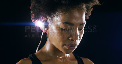 Buy stock photo Earphones, fitness and face of black woman in studio for intense training, exercise and workout. Sports, lens flare and person sweating for wellness, health and listening to music on dark background