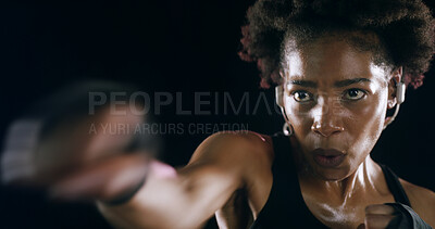 Buy stock photo African woman, punch and earphones for training, fitness and music for martial arts by black background. Girl, person and boxing with audio streaming, exercise or workout in studio for fight contest