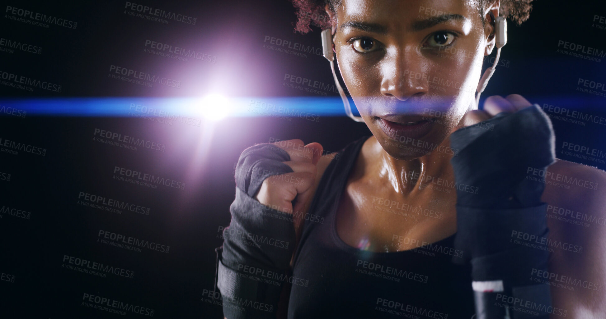 Buy stock photo Woman, boxer fighter and studio for challenge, sweating and lens flare on black background. African person, performance training and strong power with martial arts, portrait and sports earphones