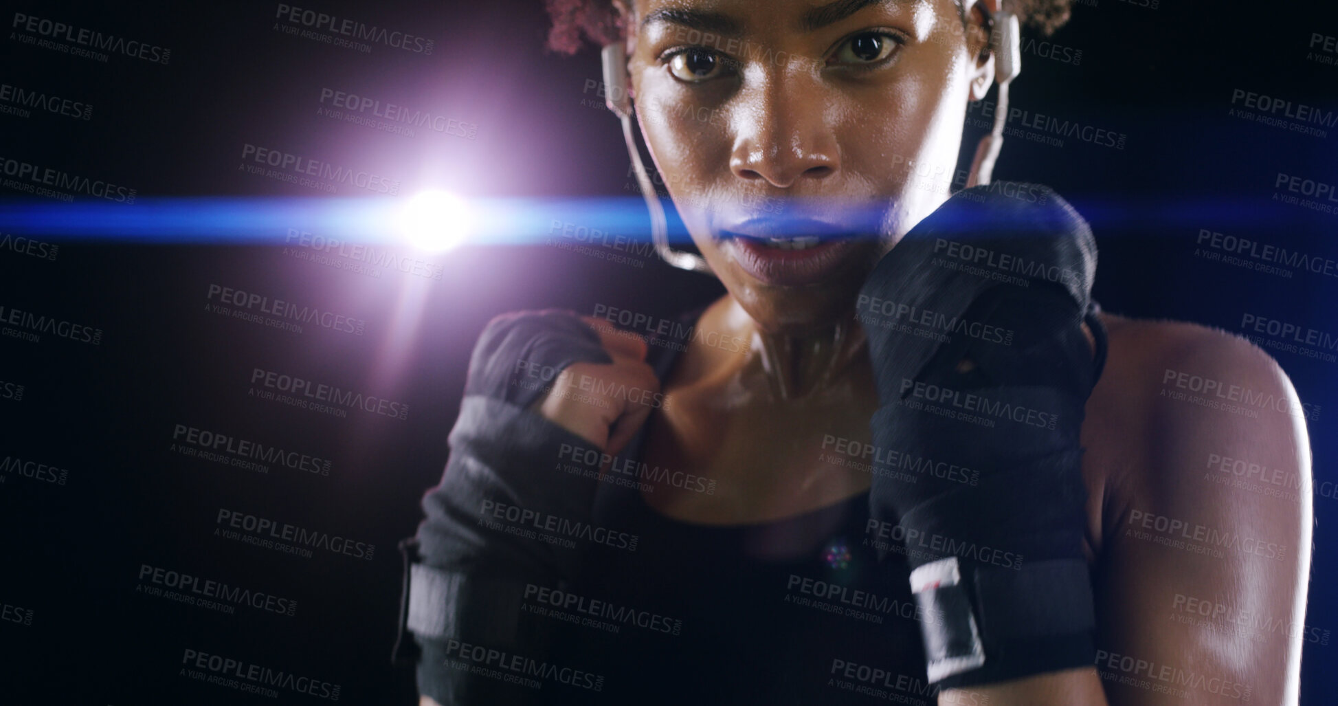 Buy stock photo Woman, boxer fighter and studio for practice, sweating and lens flare on black background. African person, performance training and strong power with martial arts, portrait and sports earphones