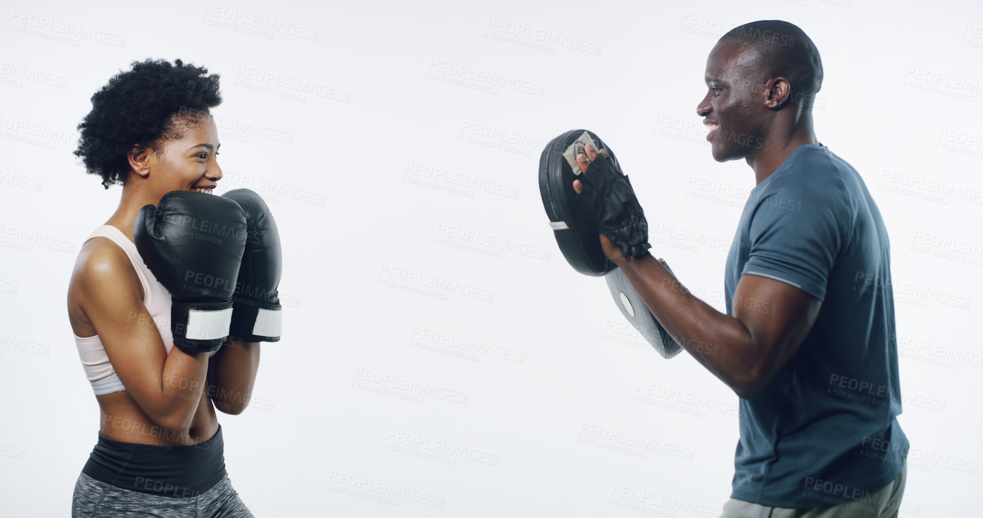 Buy stock photo Man, woman and boxing with coach in studio, smile or gloves with pads for punching by white background. African people, happy or training for self defence with martial arts, exercise and combat sport