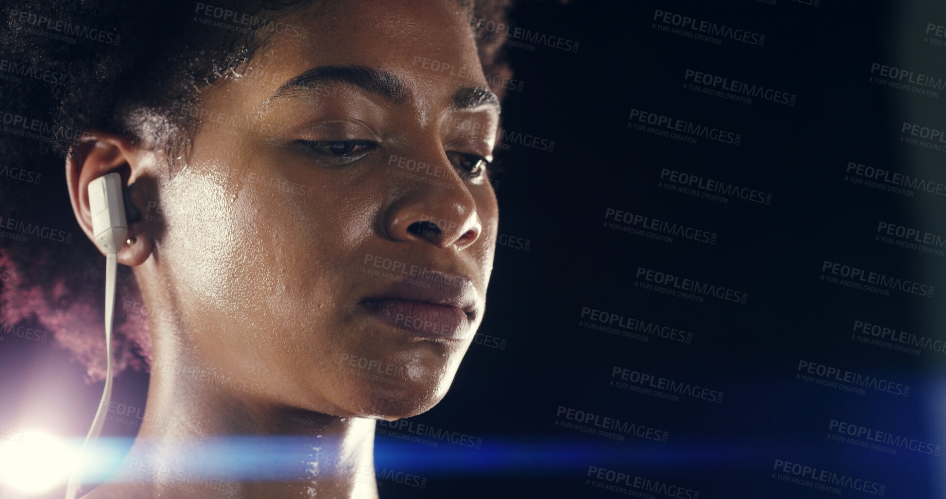 Buy stock photo Face, fitness and music with woman in studio on black background for training or workout routine. Earphones, exercise and flare with African athlete sweating on mockup space for challenge or health
