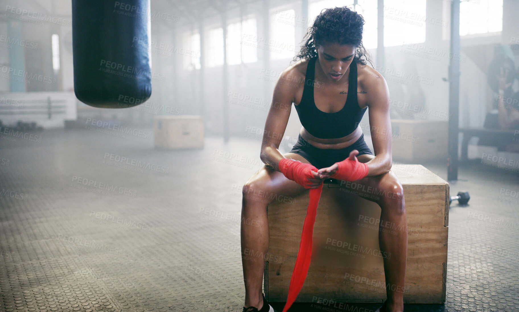 Buy stock photo Woman, bandage and boxer wrapping knuckles in gym for self defense, fighting or workout. Fitness, active female person or girl fighter with fist strap on hands for boxing safety, protection or gloves
