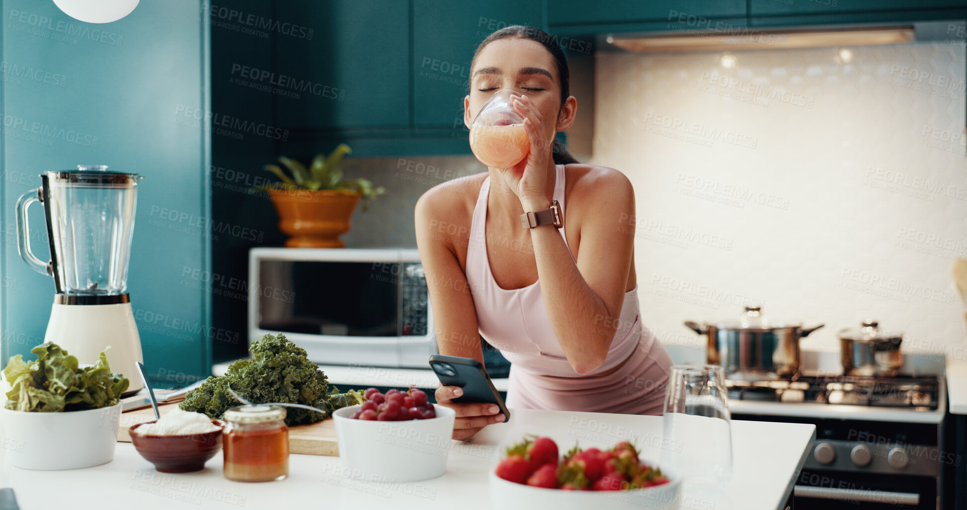 Buy stock photo Phone, kitchen and woman drinking smoothie in home for gut health, wellness and liquid breakfast. Nutrition, relax and female person enjoying organic fruit juice for detox, cleanse or weightloss.