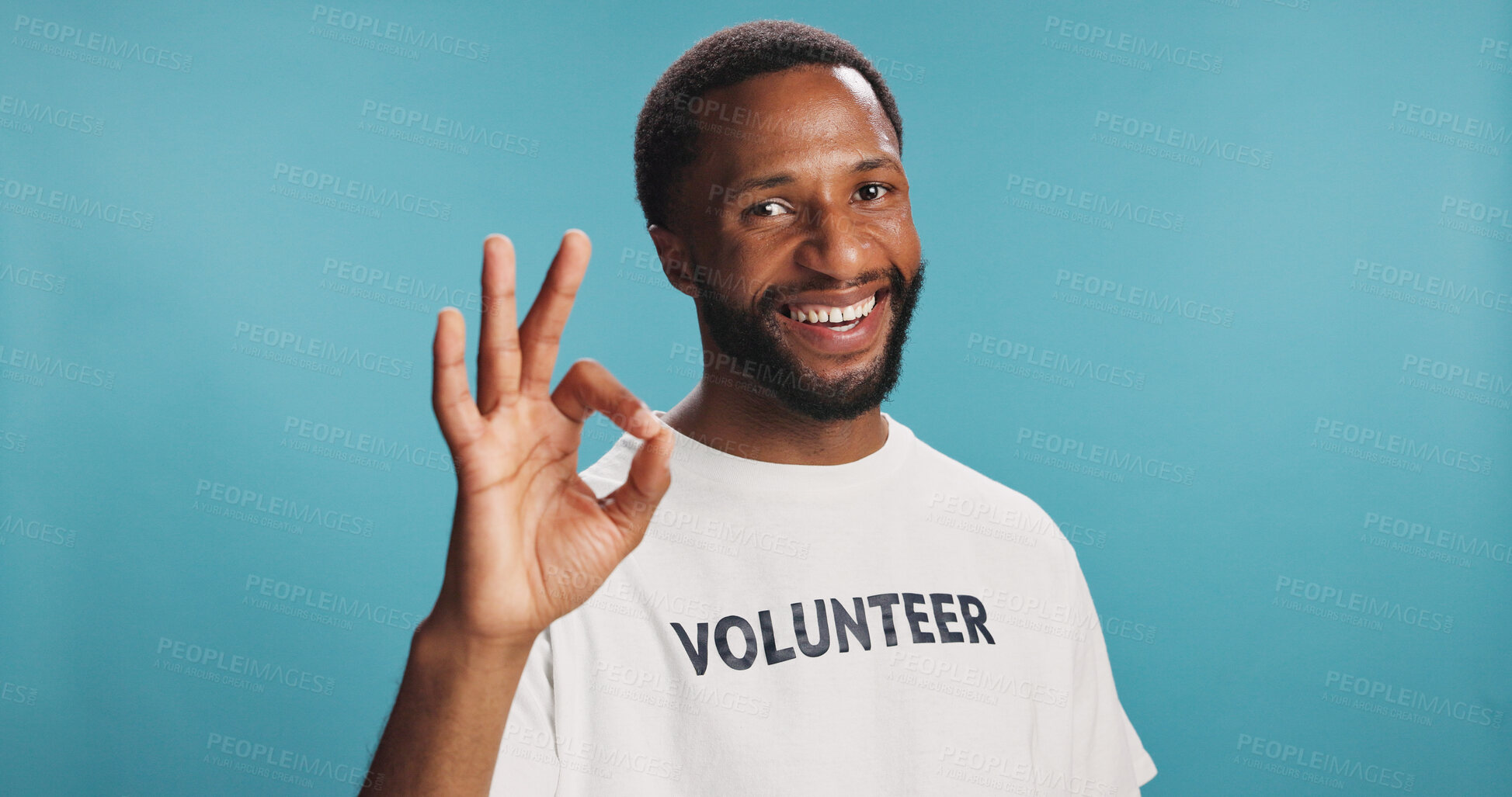 Buy stock photo Volunteer, portrait and man in studio with perfect hand gesture for ngo community project. Ok, happy and African male charity wroker with approval expression for activism by blue background.