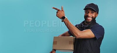 Buy stock photo Portrait, delivery man and pointing to space for shipping box, logistics or mockup on banner. African courier, smile or advertising with package for sales, promo or discount on blue studio background