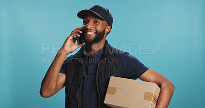 Buy stock photo Phone call, box and happy delivery man talking to contact for order update, logistics or service. African courier, mobile and communication for shipping schedule or package on blue studio background