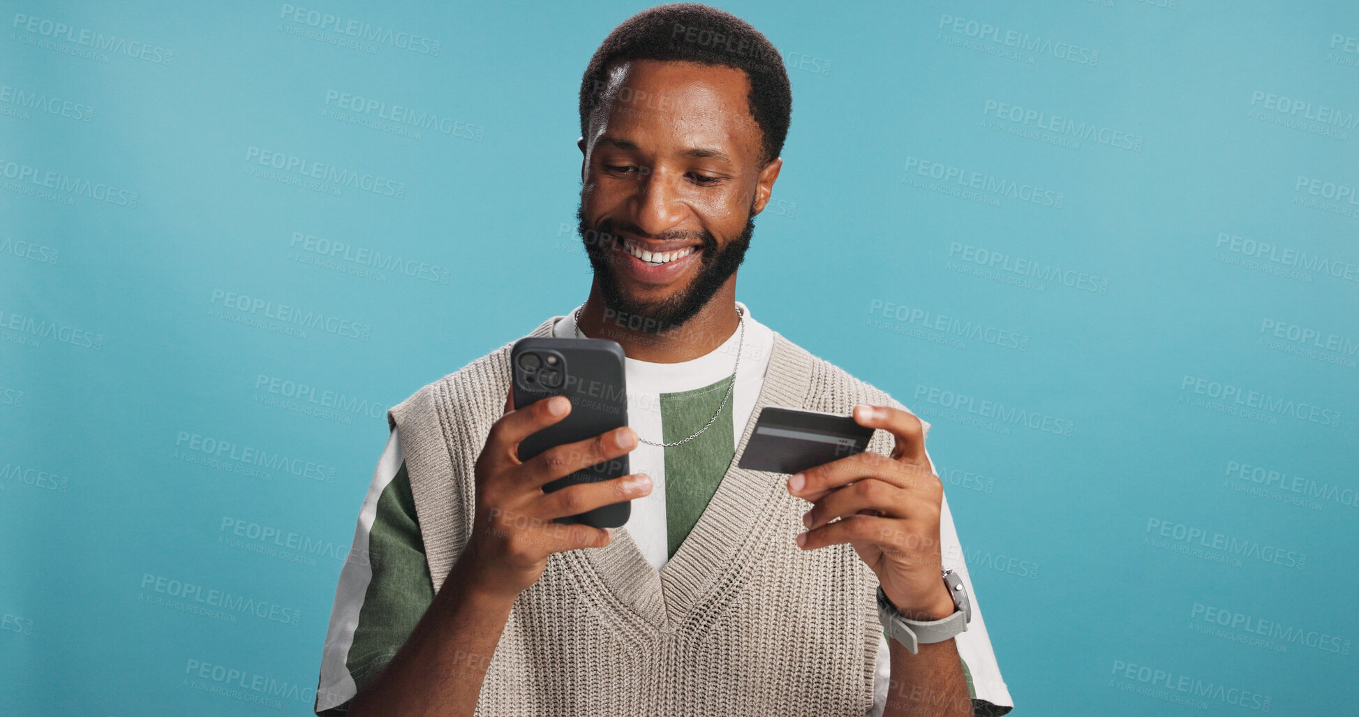 Buy stock photo Black man, credit card and phone in studio, checkout order and wireless purchase on website. Male person, online shopping and retail discount on store app, banking pin and buying on blue background