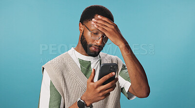 Buy stock photo Phone, scam or black man with stress reading for bad news, password error or online crisis in studio. Anxiety, hacked or frustrated person by blue background for loss, digital fraud or notification