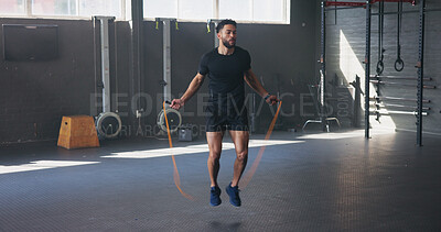 Buy stock photo Rope, fitness and man in gym, jumping and workout with training, cardio and energy. Healthy person, bodybuilder and athlete in wellness center, exercise and challenge with progress and moving