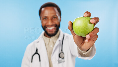 Buy stock photo Hand, doctor and happy man with apple in portrait for nutrition, healthcare clinic or healthy food choice. Studio, blue background or nutritionist giving fruit for offer, fibre and vitamin c in diet