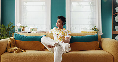 Buy stock photo Home, thinking and man on sofa, headphones and relax with smile, radio and ideas in lounge. Person, apartment and guy on couch, headset and listening to music, sound and song with podcast and calm