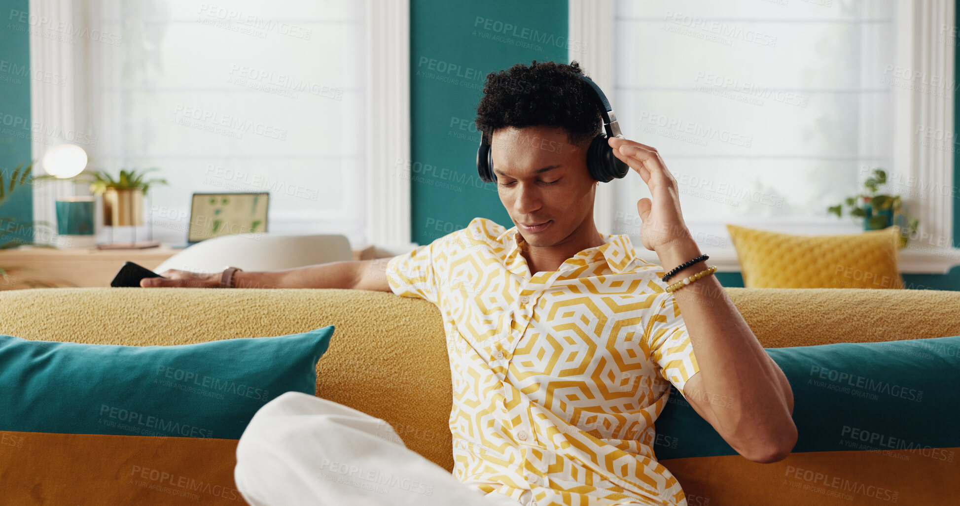 Buy stock photo Home, listening and man on couch, headphones and relax with podcast, radio and calm in lounge. Person, apartment and guy on sofa, headset and music with sound, live streaming and song with audio