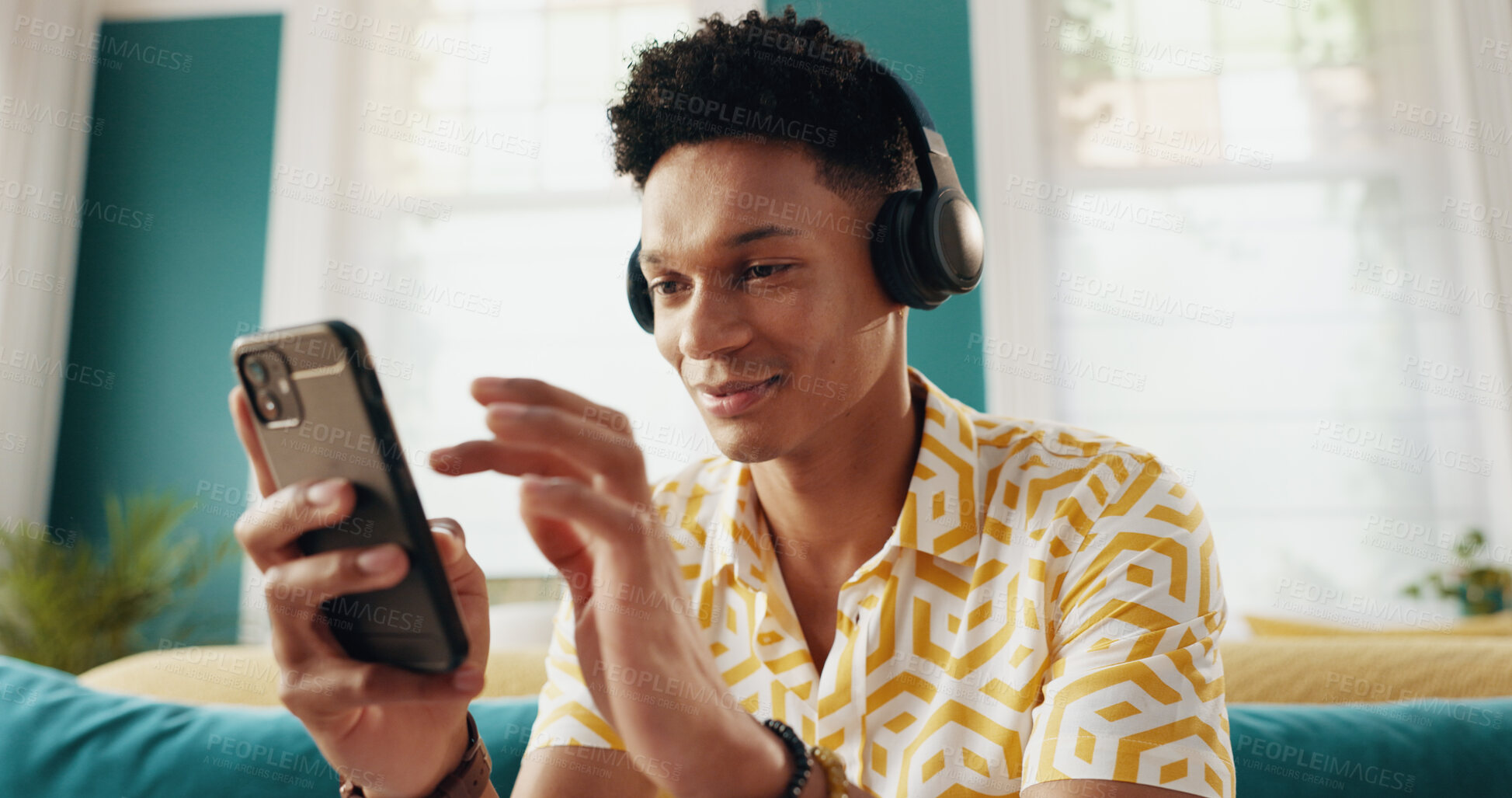 Buy stock photo Phone, headphones and man in home with music, podcast and listening to jazz album on radio to relax. Mobile, living room and person streaming sound, audiobook and scroll social media app on internet