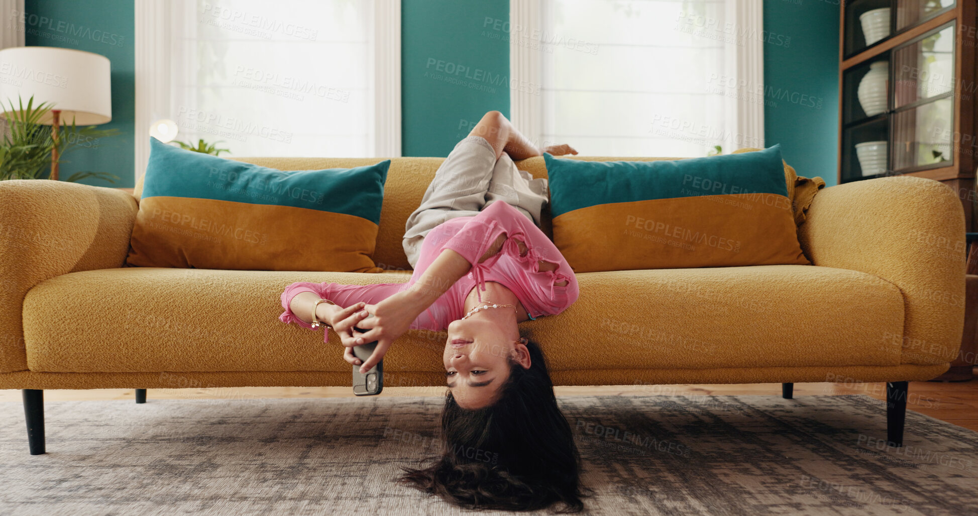 Buy stock photo Phone, upside down and woman relax in home, reading text and post on social media profile online. Mobile, sofa and girl on chat app for communication, check notification and message on internet forum