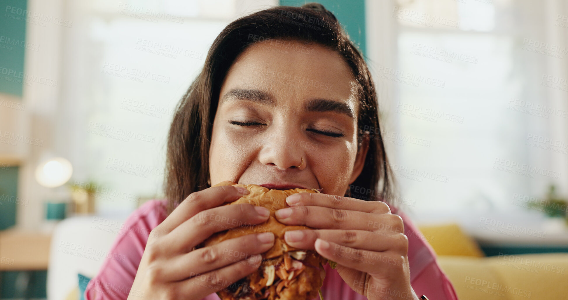 Buy stock photo Home, burger and hungry woman eating fast food, unhealthy meal and takeaway to relax in living room. Nutrition, hamburger and girl enjoy lunch order, beef sandwich or meat for diet or snack addiction