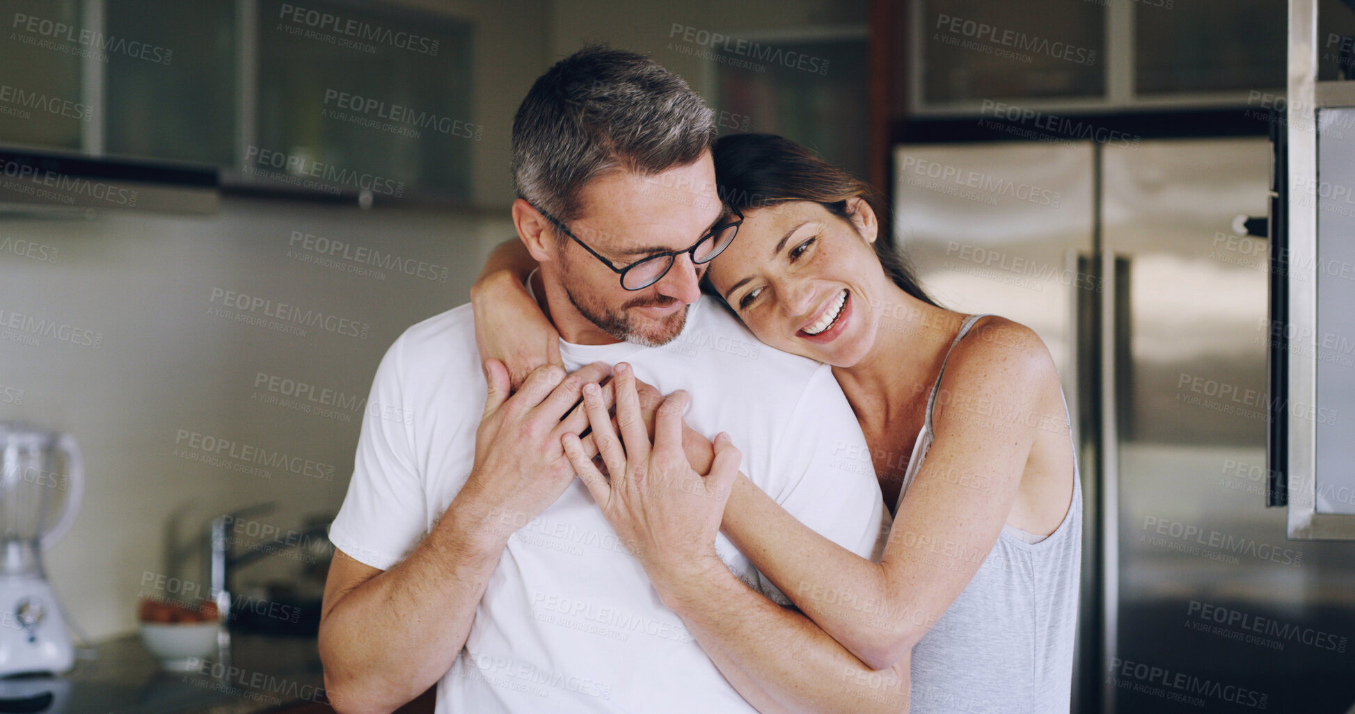 Buy stock photo Happy couple, hug and smile with romance for love, embrace or bonding together in kitchen at home. Woman, man or lovers with care, comfort or satisfaction for marriage and weekend morning support