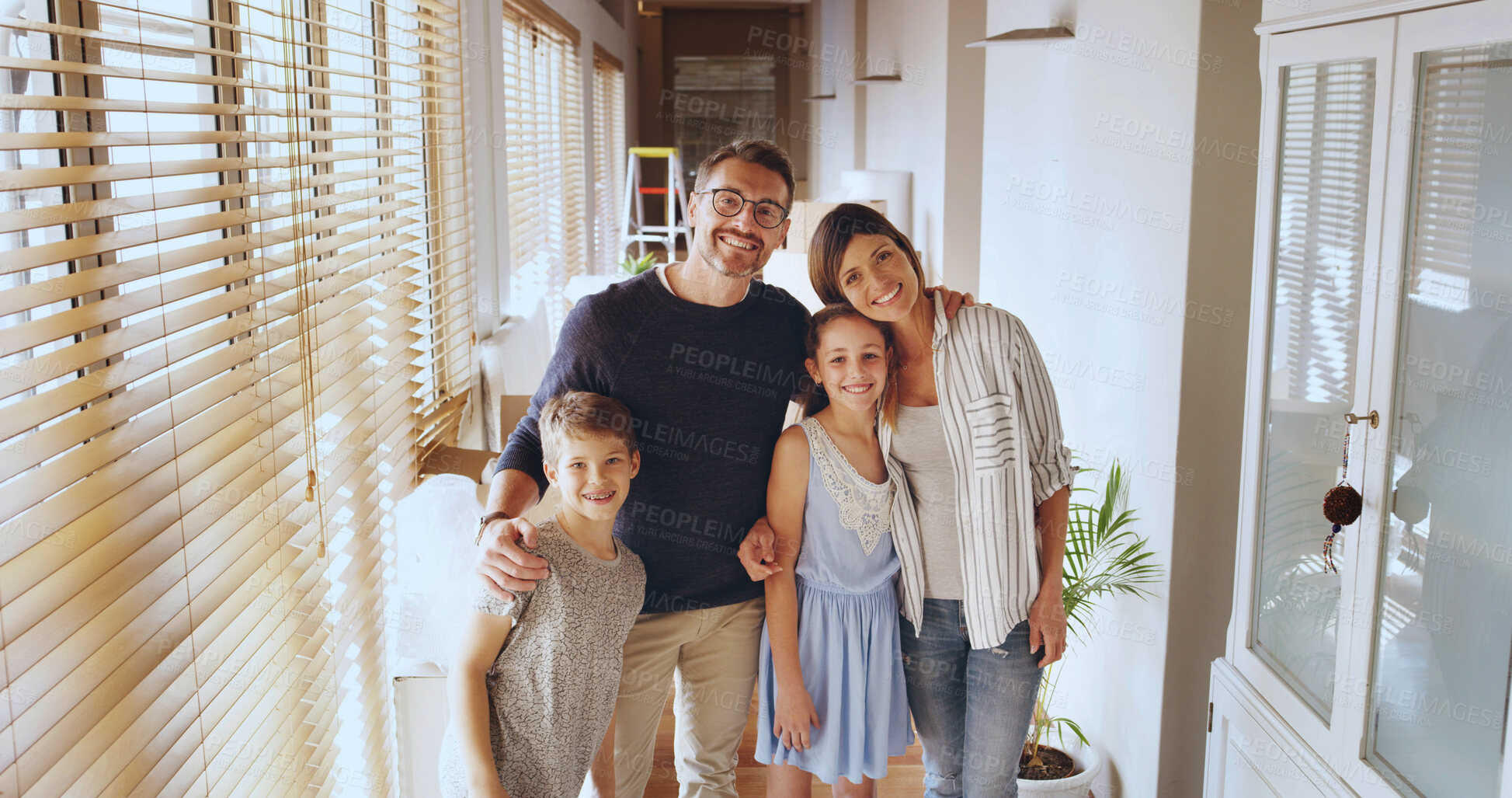 Buy stock photo Parents, children and happy with hug in home, portrait or care with love, pride and bonding in hallway. Mother, father and kids with embrace, people and smile in family house with support in Portugal