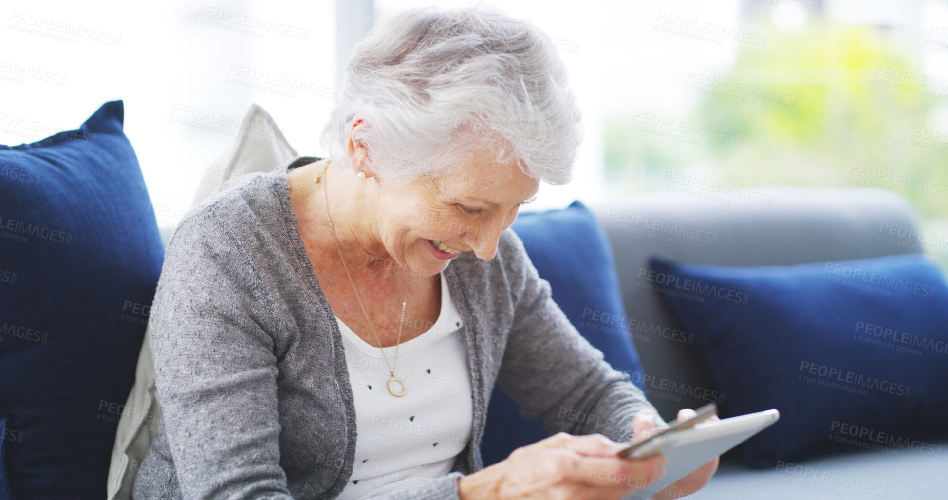Buy stock photo House, tablet and senior woman on sofa, typing and internet with self help video in lounge. Pensioner, apartment and elderly lady on couch, technology and digital app for texting, smile or connection