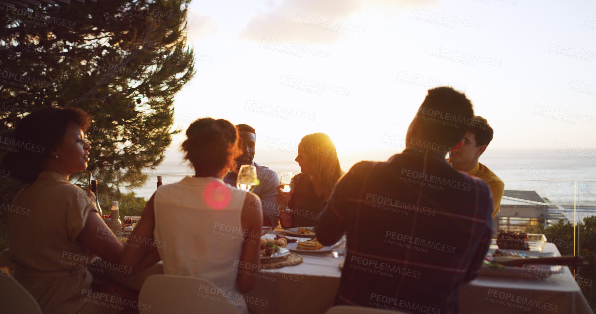 Buy stock photo Dinner party, food and sunset with friends on balcony of restaurant together for reunion. Accommodation, eating or hospitality with man and woman group at table for bonding, celebration or meal