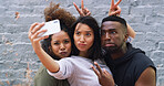 Selfie, comic and group of friends by wall in city for memory, social media or profile picture on holiday. Funny, goofy and young people with photography picture for content creation vlog in town.