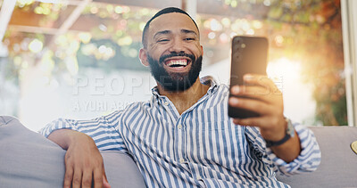 Buy stock photo Video call, phone and laughing with man on sofa for connection, virtual chat and social media. Streaming network, distance communication and internet with person in living room at home for app