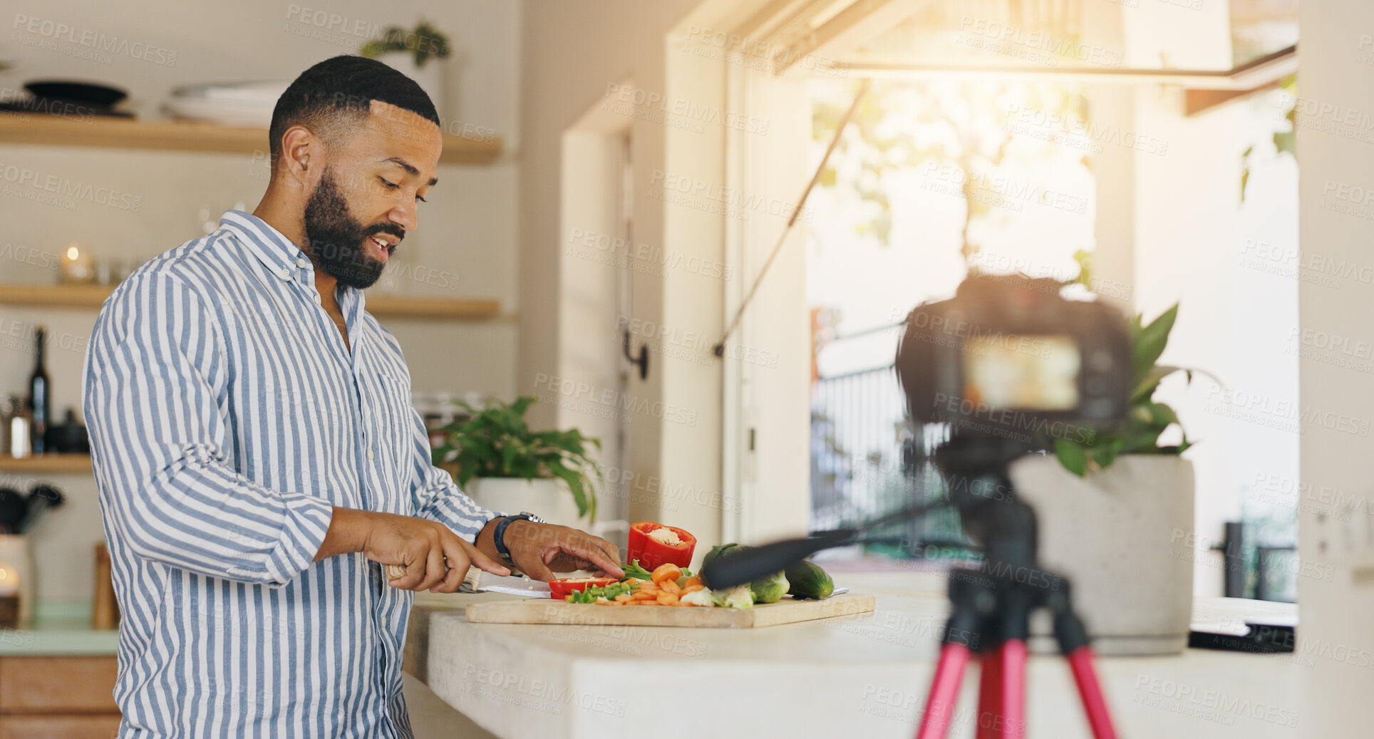 Buy stock photo Camera, live streaming and man in kitchen for cooking tutorial, cuisine and meal preparation in home. Culinary influencer, content creator and person with food, recipe or ingredients for social media