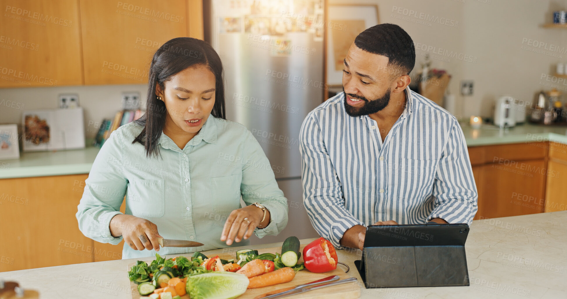 Buy stock photo Couple, tablet and cooking recipe in home, cutting vegetables and online for meal instructions. People, website tutorial and organic ingredients for healthy salad, love and guidance with nutrition