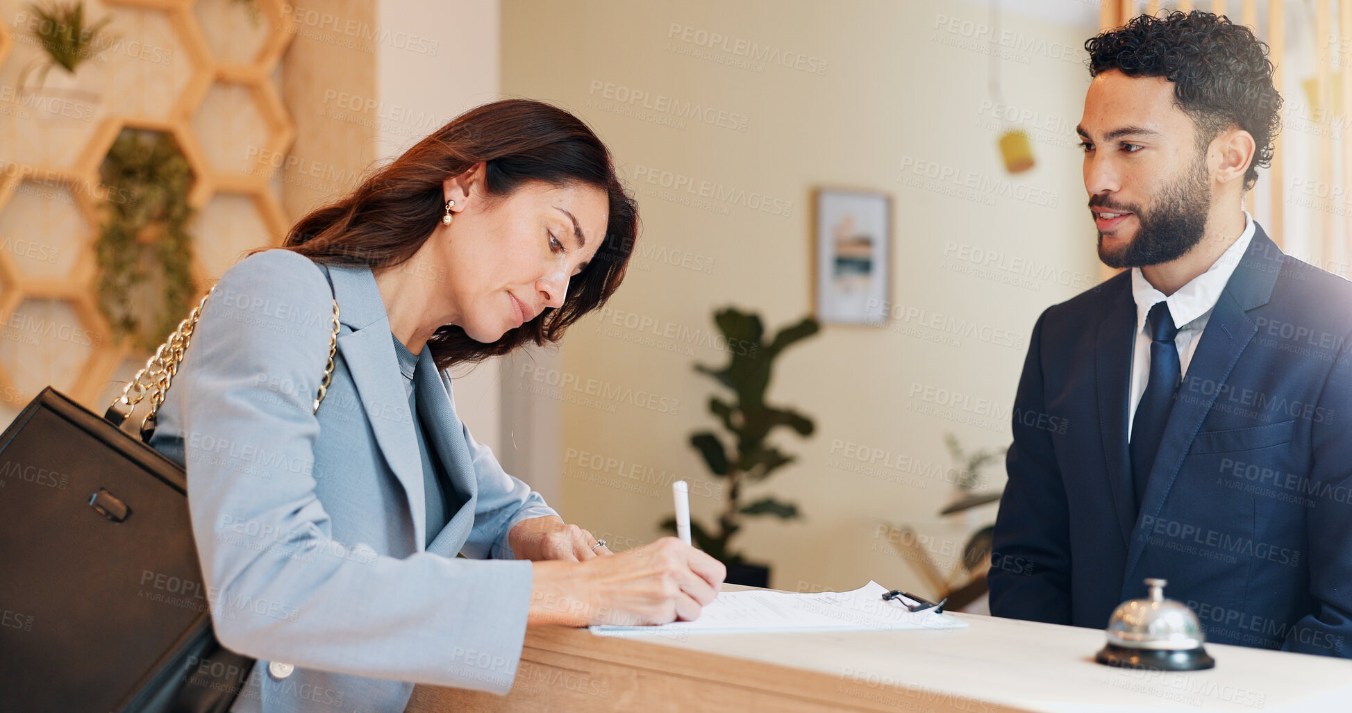 Buy stock photo Hotel, signature and woman at desk with man, paperwork and reception service for hospitality. Check in, registration and receptionist with client at counter for accommodation, booking or travel