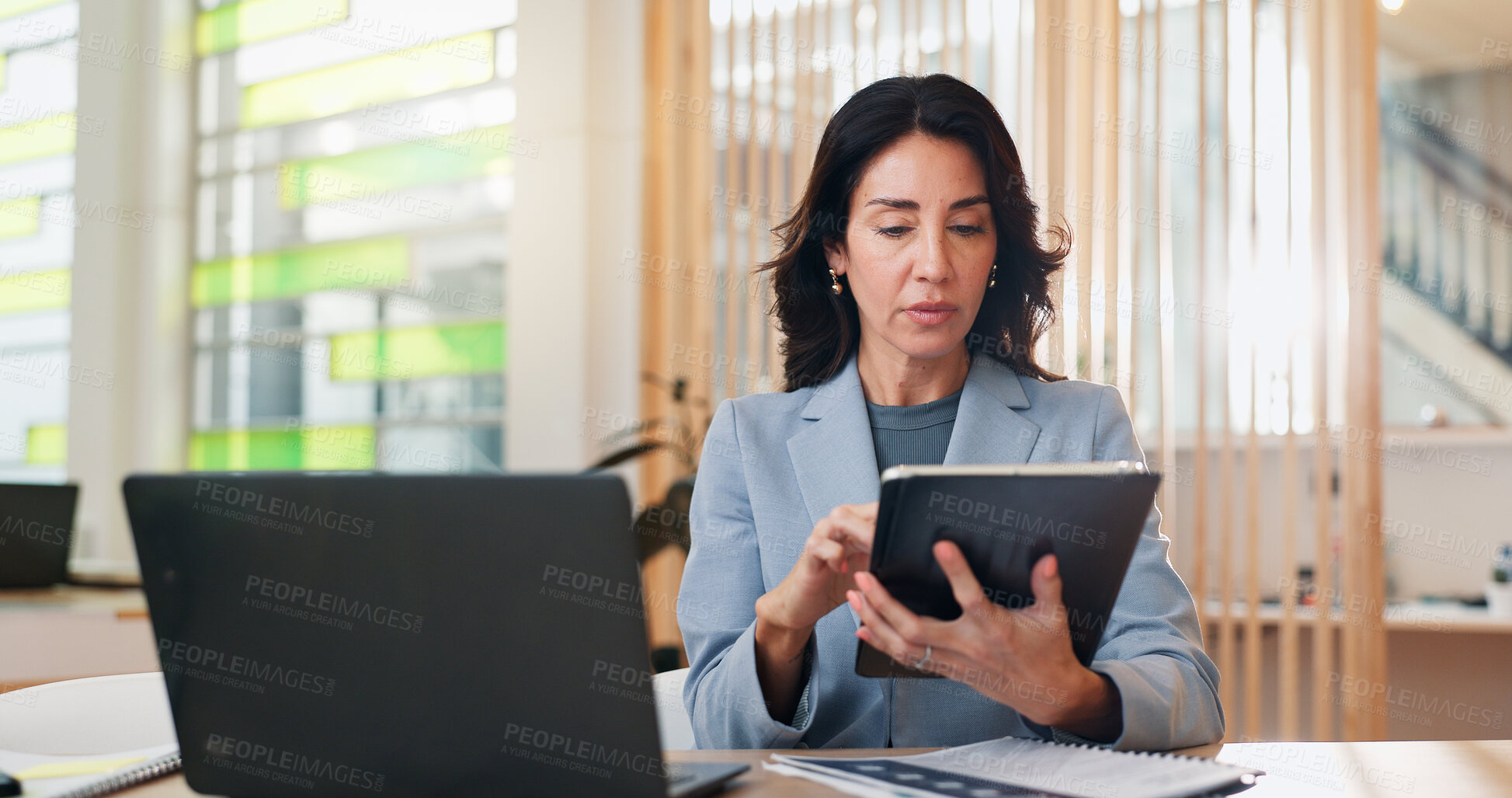 Buy stock photo Business, laptop and tablet with graphic designer woman at desk in office for editing of company web page. Artistic, creative and search with serious mature employee in workplace for development