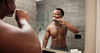 Buy stock photo Black man, mirror and brushing teeth in bathroom for oral care, morning routine and wellness on vacation. Person, toothbrush and reflection in luxury apartment with cleaning for gingivitis prevention