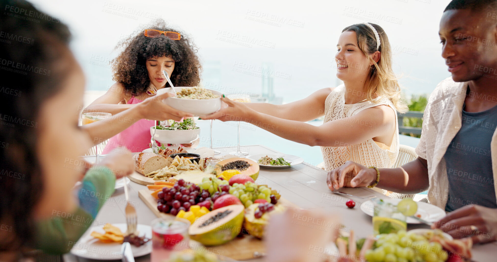 Buy stock photo Happy people, eating or passing with food at resort for lunch, meal or get together by table. Group, hungry friends or event with bowl, hospitality or dining for feast, holiday party or weekend