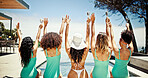 Bachelorette, beach hotel and hand raised with friends outdoor together for holiday or vacation. Back, bikini or resort pool and woman and bridesmaids drinking champagne in celebration at resort