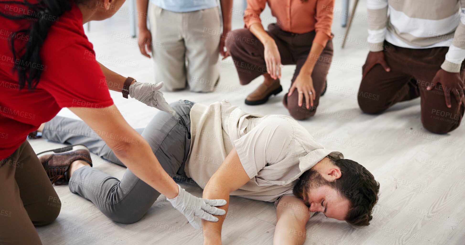 Buy stock photo People, demonstration and class for first aid, teaching or recovery position to prevent aspiration. Floor, life saving and learning to rescue person with seizure, healthcare or side technique for CPR
