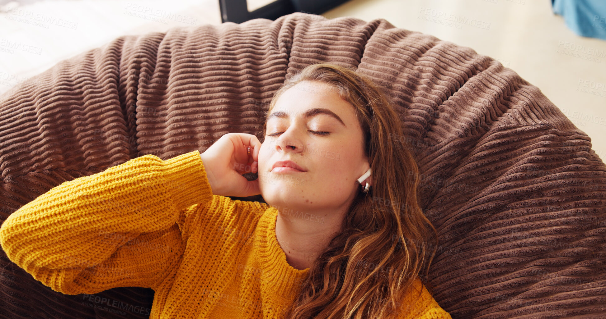 Buy stock photo Listening, calm and woman with earphones, relax and comfortable on couch in home, student and morning. Living room, resting and streaming of music on sofa, audio and break in apartment for university