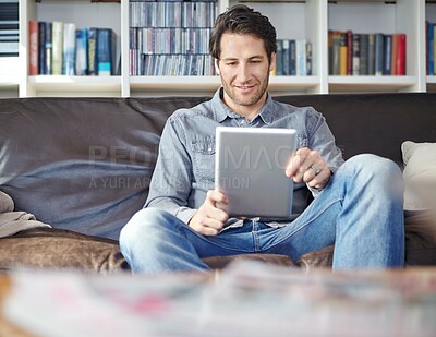 Buy stock photo Man, tablet and streaming in home on website, communication and relax in living room on social media. Male person, online and surfing subscription on app, reading and ebook for entertainment on sofa