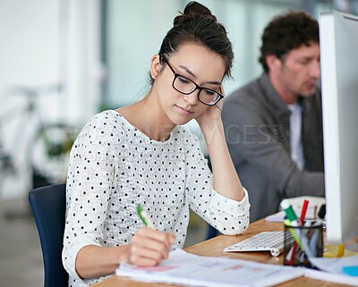 Buy stock photo Shot of a beautiful young woman working at her desk in an office