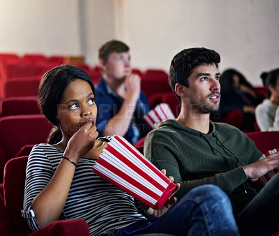 Buy stock photo Thriller, movie and couple in cinema on date with popcorn to relax and watch in theatre with suspense. Film, experience and people in audience enjoy horror, drama performance or eating snack food