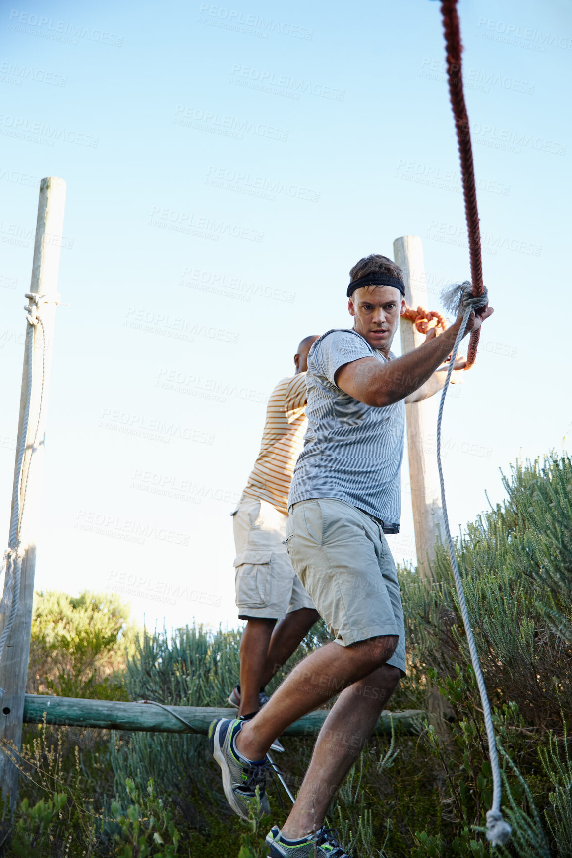 Buy stock photo Athlete, men and walking on rope outdoor for physical strength, training and body balance. Active, people and climbing for obstacle course, survival test and exercise of workout challenge at bootcamp