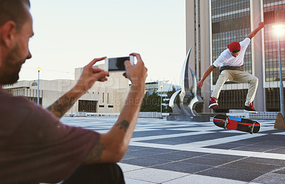 Buy stock photo Man, skateboard and picture with camera for jump trick, content creation or vlog in an urban town or city. Male person, photographer and capture with phone at skate park for flip stunt or online post