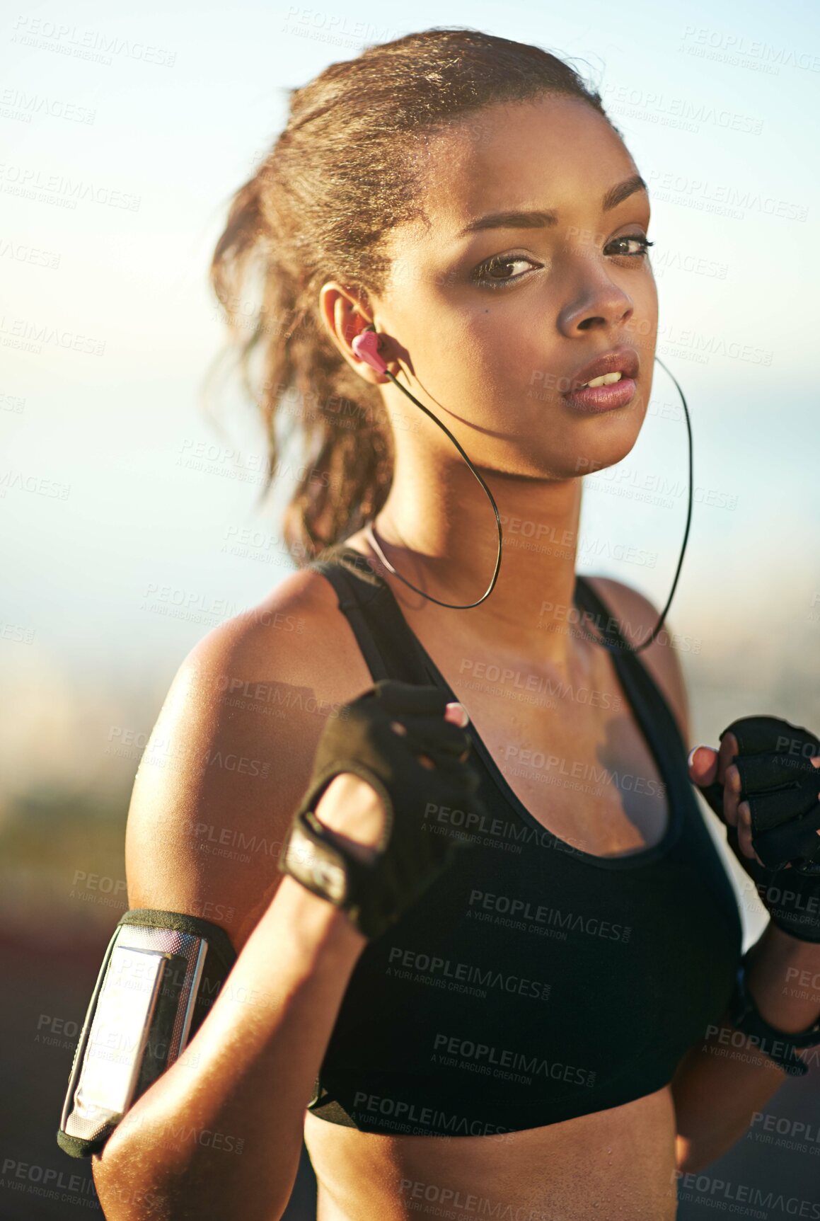 Buy stock photo Woman, portrait and outdoor exercise as boxer with fists or earphones or cellphone arm strap, fitness app or fighter. Female person, face and music listening for outside cardio, nature or training