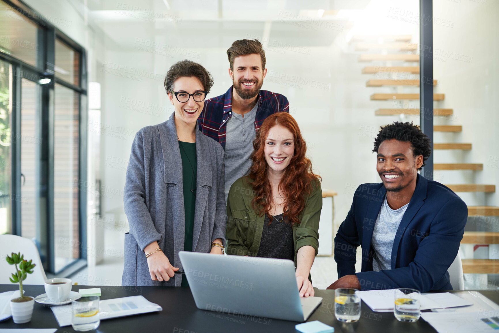 Buy stock photo Portrait of a group of young creatives working together on a laptop in a modern office